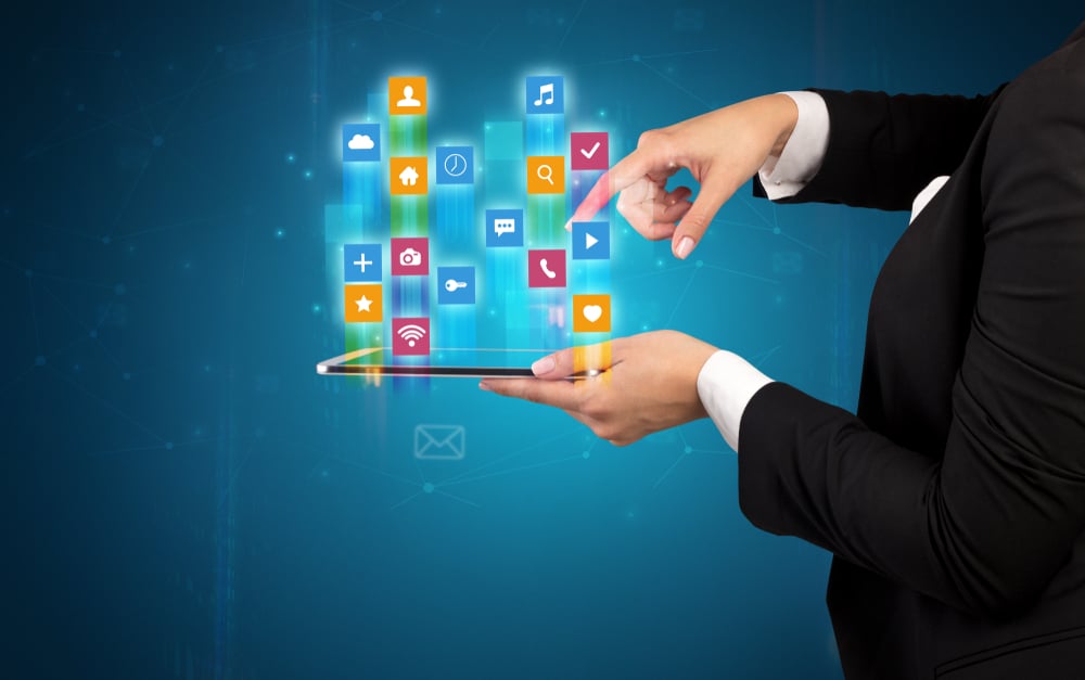 Female elegant hand holding tablet with colourful application icons